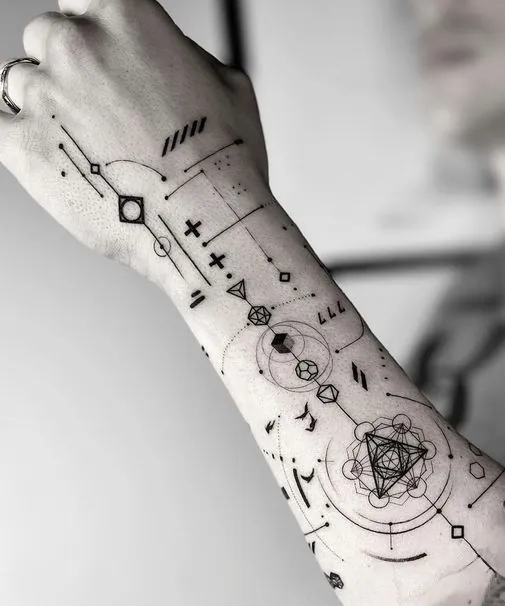 Geometric linework tattoo of triangles, circles and dots running from the hand to the wrist
