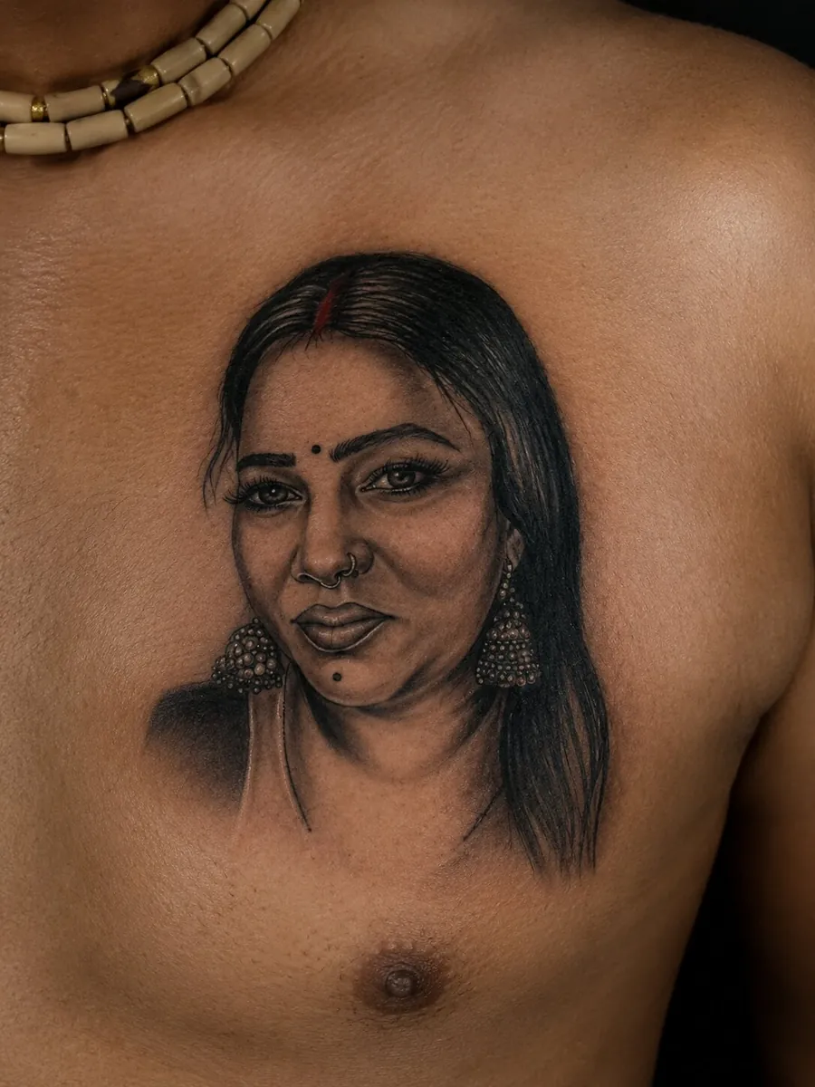 Black and grey realistic portrait tattoo of a woman on the chest